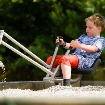 Boy using sit on gravel play digger